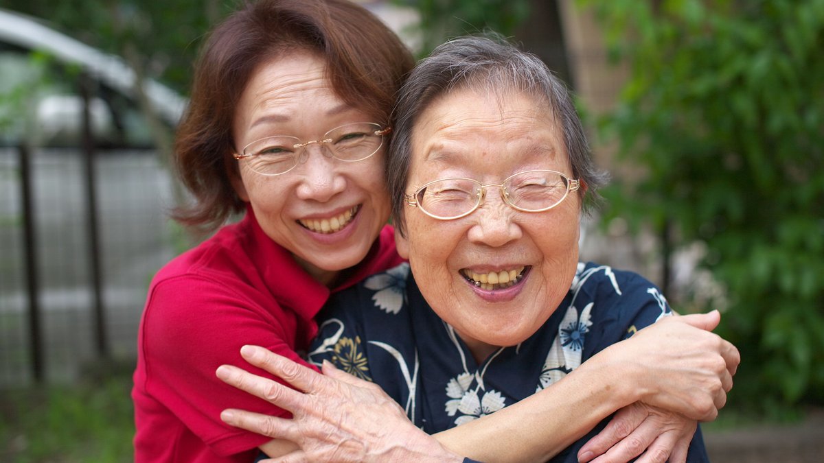 Happy mother and daughter embracing outside, showcasing love and joy.