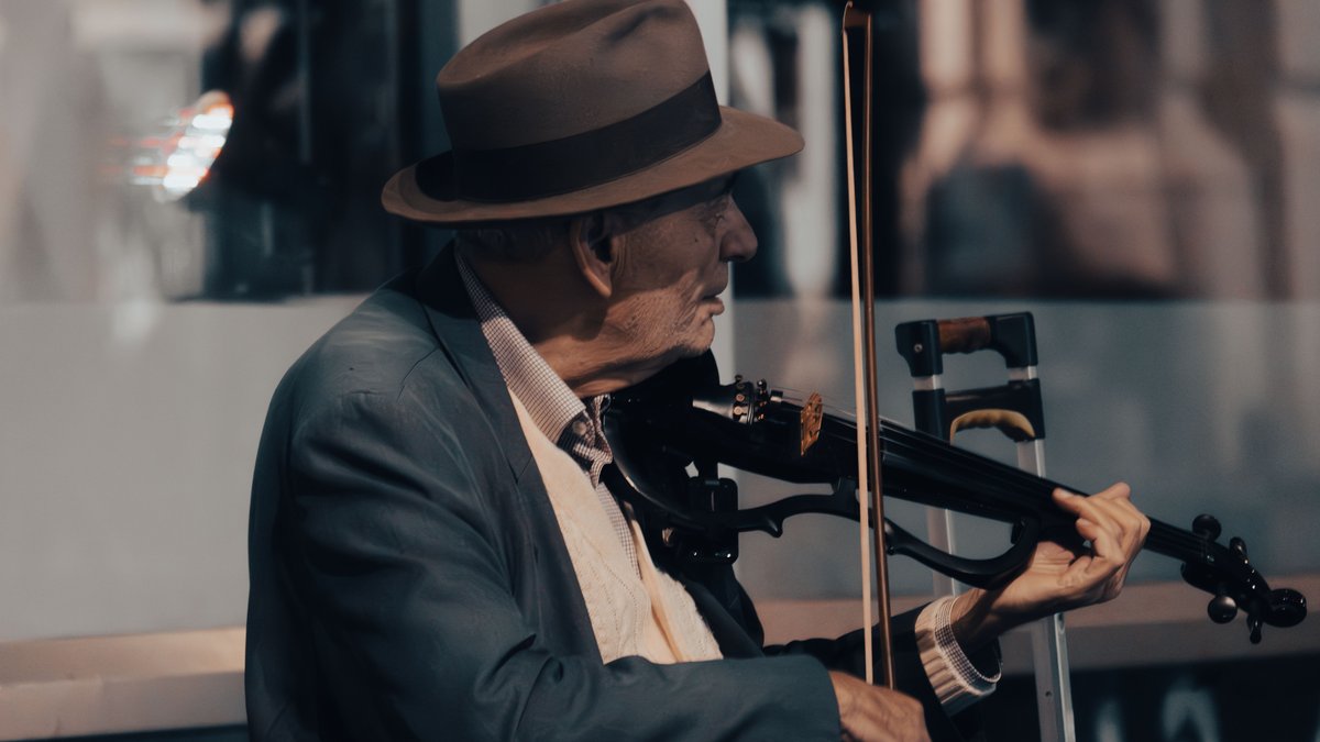 Elderly street musician passionately plays violin in Bucharest, Romania.