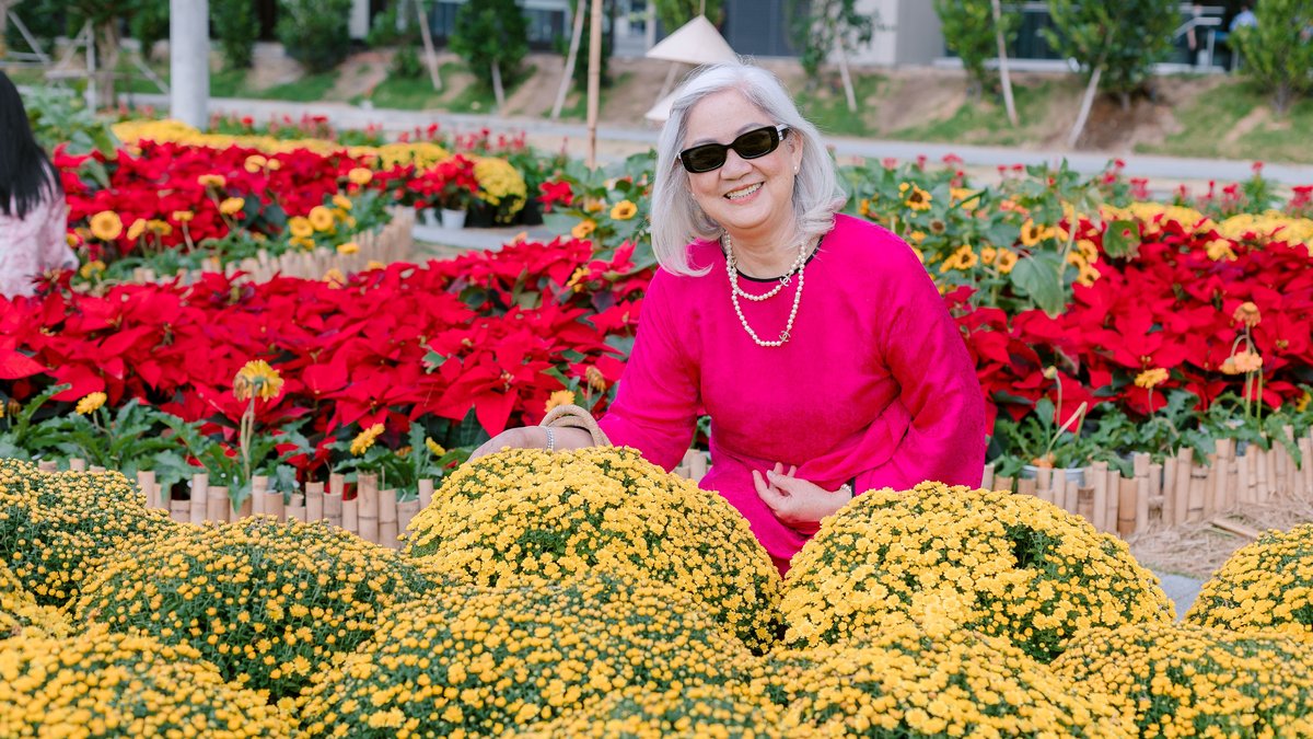 A joyful senior woman in a vibrant flower garden, surrounded by vibrant blossoms.