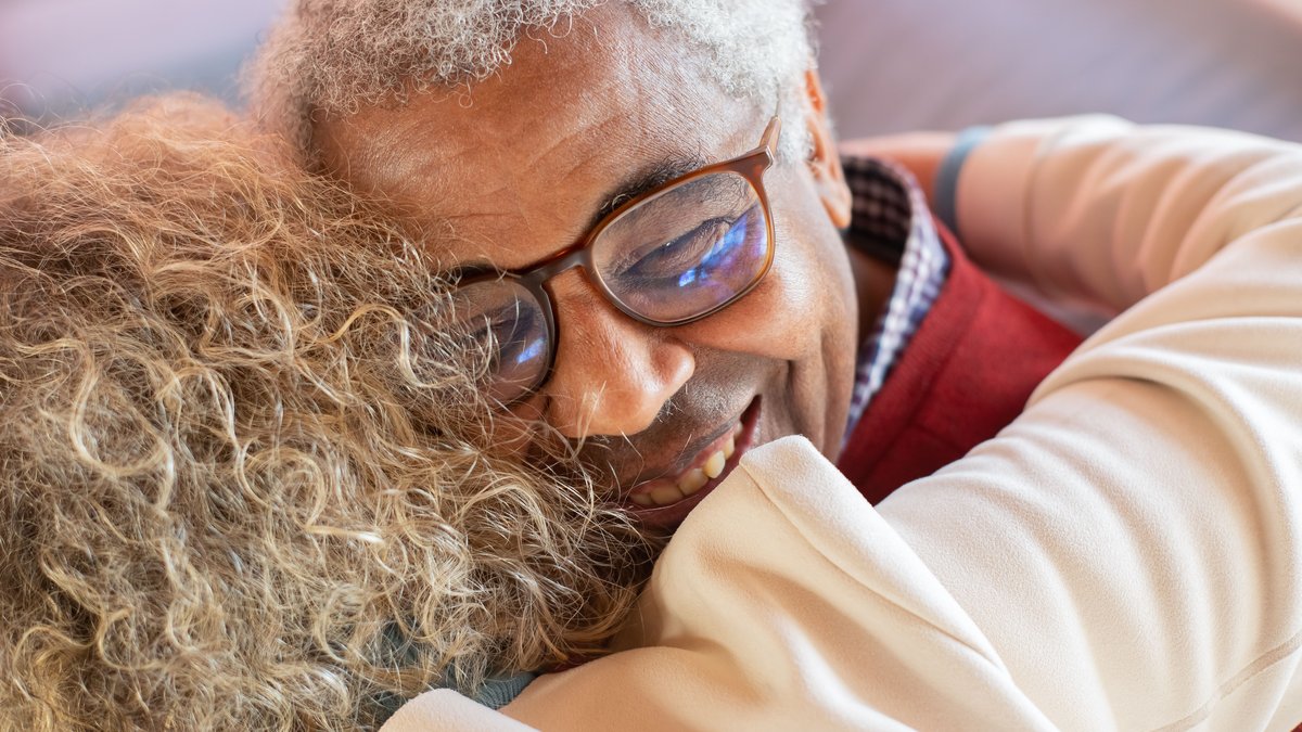 Heartwarming close-up of a senior couple embracing joyfully, showcasing love and happiness.
