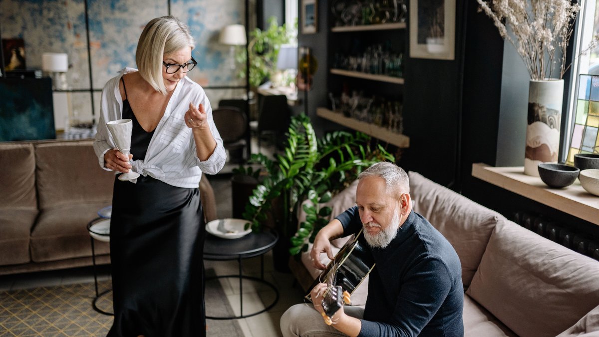 A senior couple enjoys music and relaxation at home, creating a warm and intimate atmosphere.