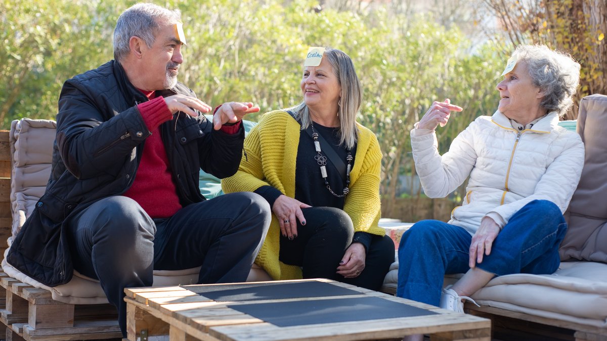 Three happy senior adults enjoying a fun game outdoors, embracing positive aging.