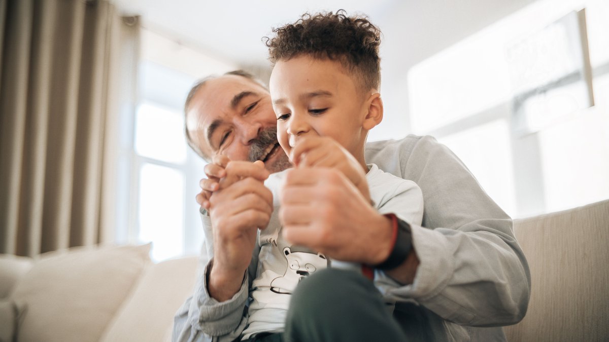 A grandfather and grandson enjoying playful quality time at home, showcasing family bonding.