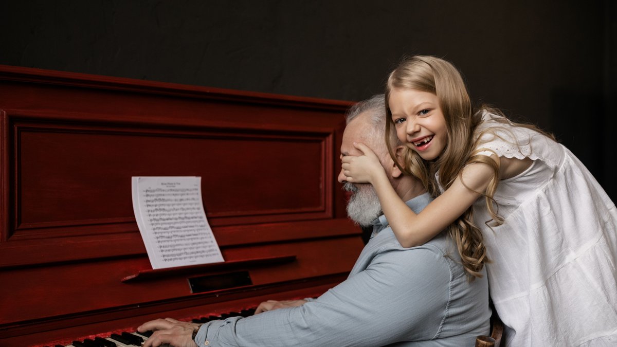 Joyful moment as granddaughter surprises grandfather at the piano, surrounded by love and music.