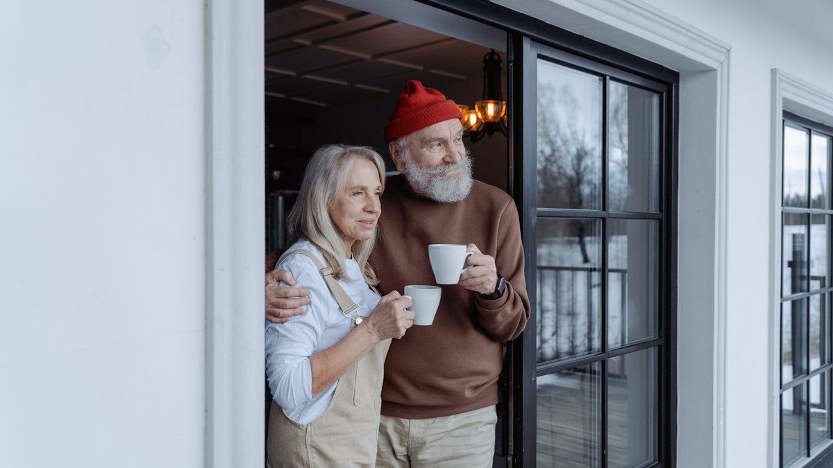 Happy senior couple enjoying coffee together at home, embracing love and warmth.
