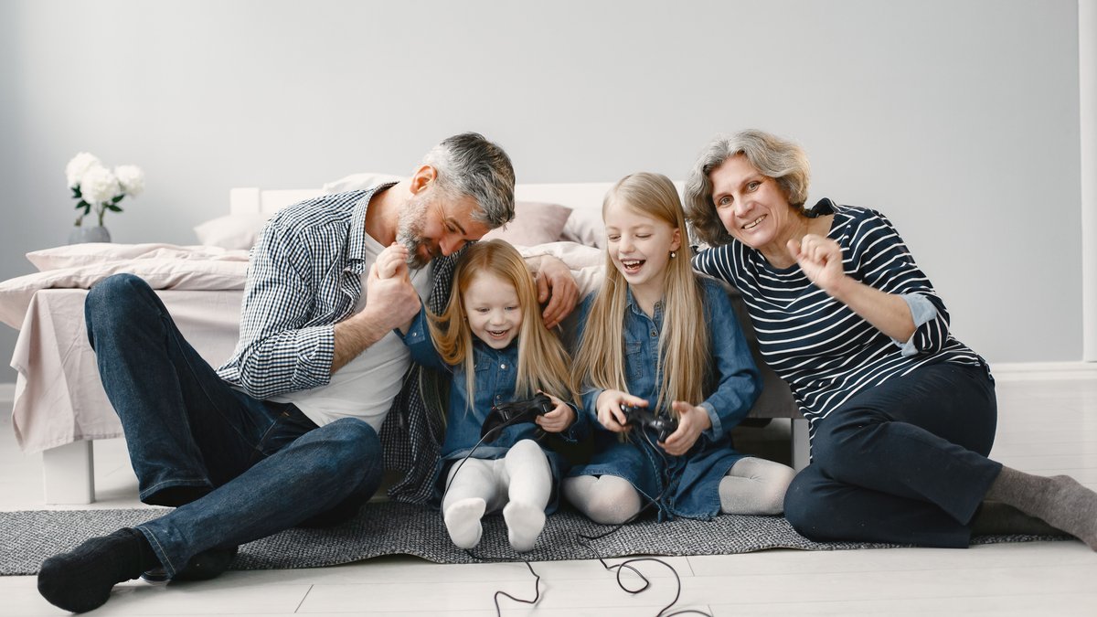 A joyful family scene of grandparents and grandchildren playing video games together at home.