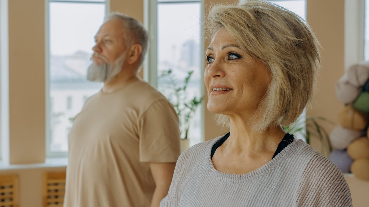 Senior couple at a wellness studio enjoying yoga and relaxation indoors.