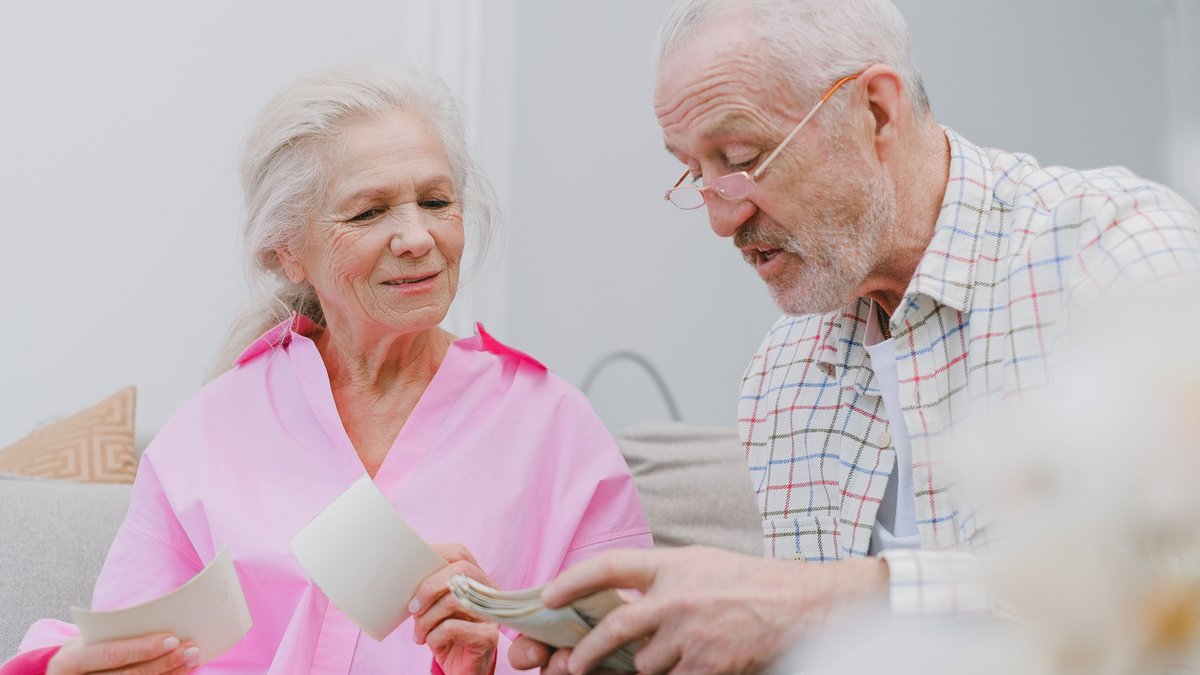 Senior couple enjoying time together while looking at photographs, smiling and reminiscing.