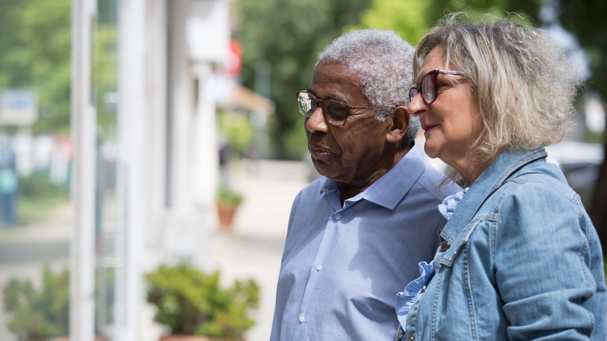 A close-up of a joyful elderly couple walking outdoors, enjoying a sunny day.