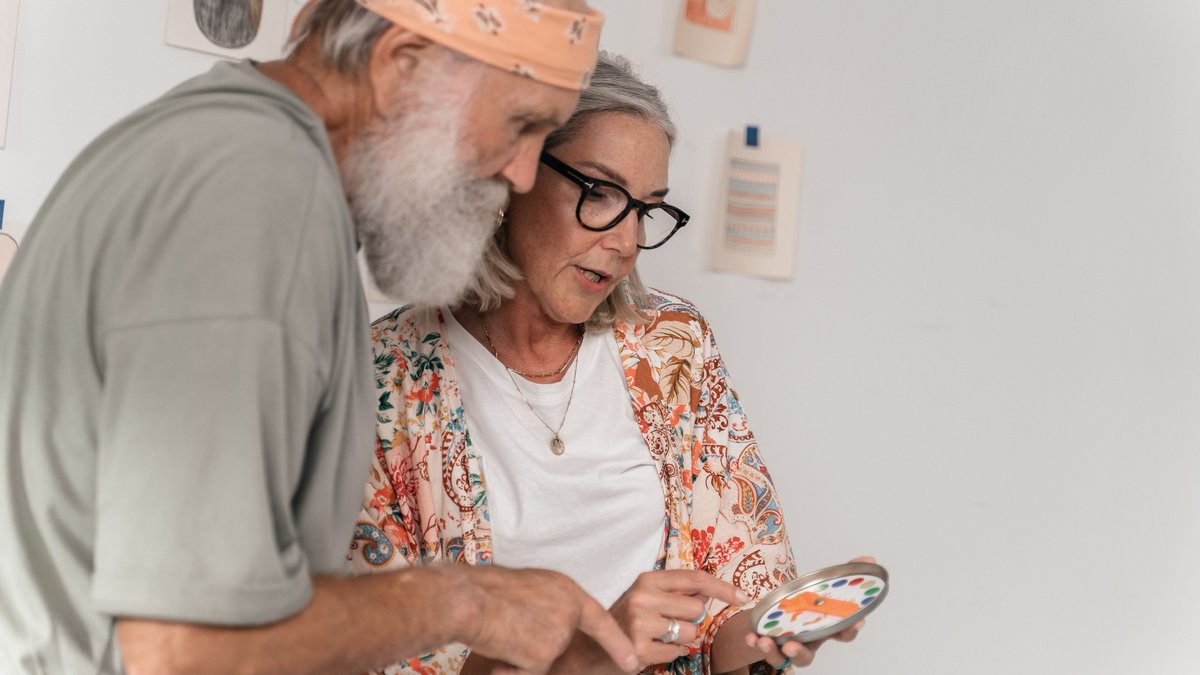 Elderly couple exploring a creative project together indoors.